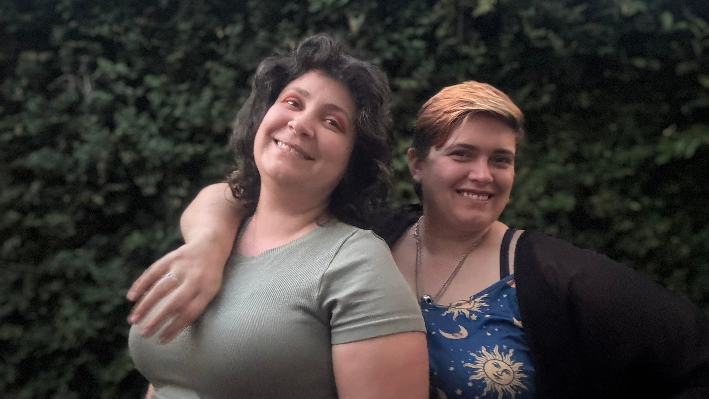 Amanda and Velvet in front of a hedge wall